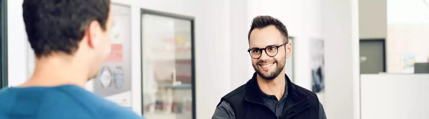 Kunde redet mit Mitarbeiter im Büro