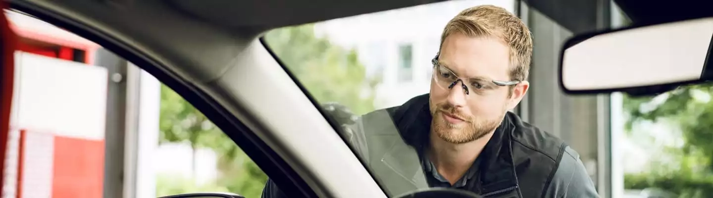 Monteur inspiziert Autoscheibe