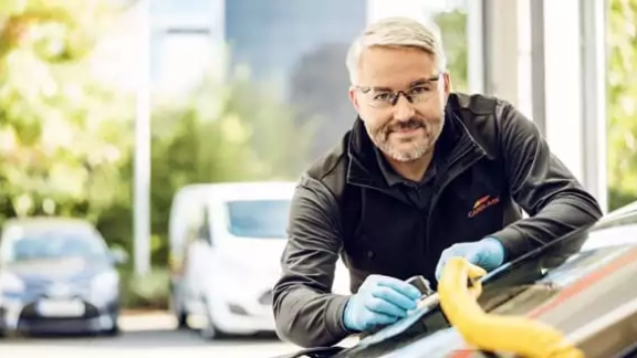 Mitarbeiter repariert Windschutzscheibe