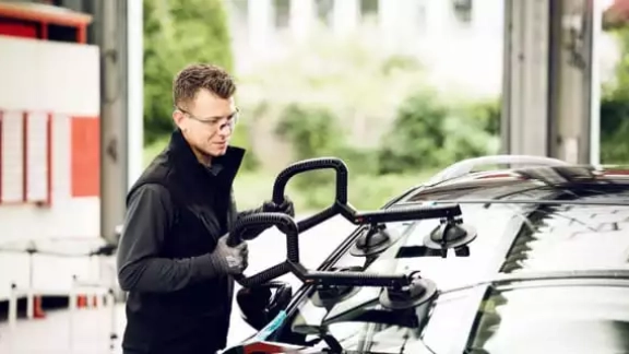 Mitarbeiter tauscht Windschutzscheibe aus