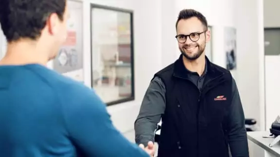 Mitarbieter und Kunde reichen sich die Hand