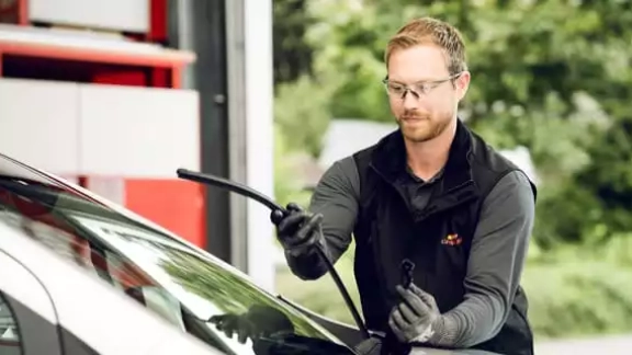 Mitarbeiter tauscht Scheibenwischer aus